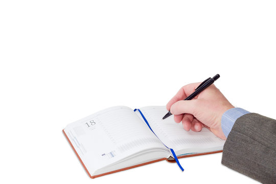 Male hand with pen over business diary on light background