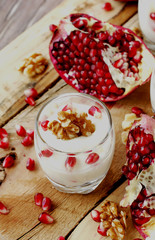 yogurt dessert with walnuts and pomegranate selective focus