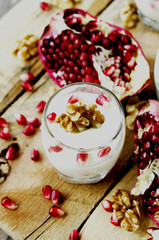 yogurt dessert with walnuts and pomegranate selective focus
