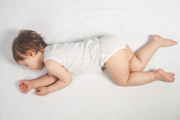Naklejka premium Newborn baby sweet sleeping on a white bed