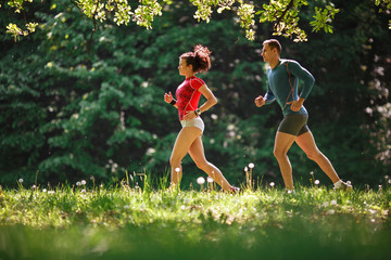 Amidst nature's beauty, a young couple enjoys a refreshing jogging, savoring the fresh air and beautiful spring surroundings.