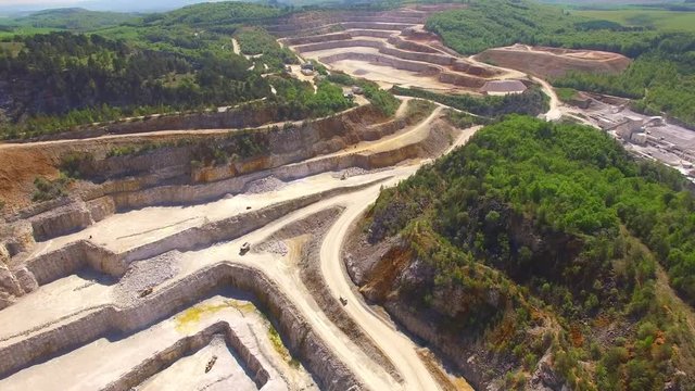 Flight over open cast mine. Biggest Czech limestone quarry Devil's Stairs - Certovy Schody. Aerial view of industrial landscape after mining. Industry and environment in Czech Republic, Europe. 