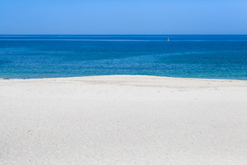 Fototapeta na wymiar Beautiful white sand beach with blue sea and blue sky