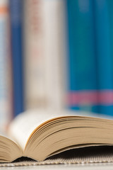 Obraz premium Detail view of open book in library. Shallow depth of field. Vertical shot.