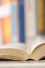 Detail view of open book in library. Shallow depth of field. Vertical shot.