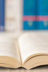 Detail view of open book in library. Shallow depth of field. Vertical shot.