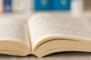Obraz premium Detail view of open book in library. Selective focus. Horizontal shot.