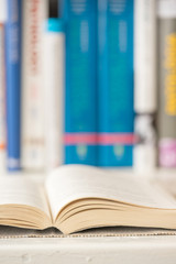 Fototapeta premium Detail view of open book in library. Selective focus. Vertical shot.