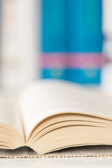 Macro shot of open book in library. Selective focus. Vertical view.