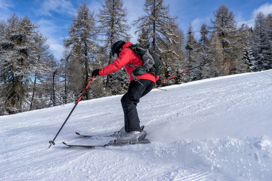 Female skier dressed in red jacket enjoys slopes in Italy. Folgaria, Trentino, Italy.
