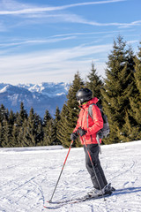 Female skier on italien slopes with mountains in distance. Vertical detail shot.