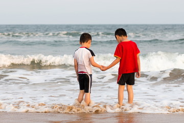 Two cute brothers playing on the beach