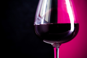 glass of red wine is on the red background