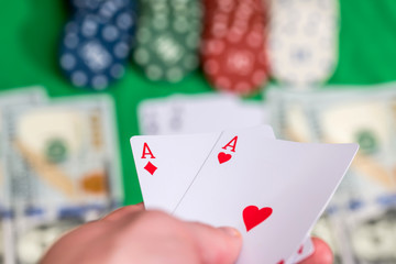 two aces in hand with poker card, chips  and money