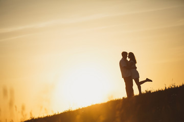 Fototapeta premium Couple kissing at sunset.