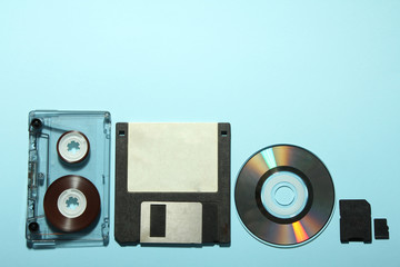 audio cassette with a floppy disk and dvd with a MicroSD on a blue background