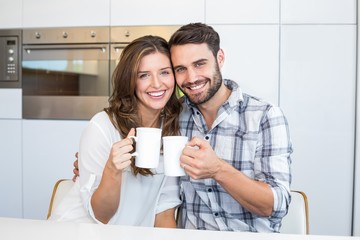 Happy couple drinking coffee by table