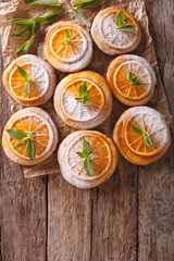 Homemade cookies with almonds and oranges close-up paper. vertical top view 
