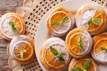 Festive cookies with oranges closeup on a plate. Horizontal top view
