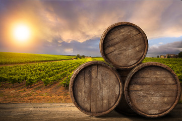 Red wine with barrel on vineyard in green Tuscany, Italy