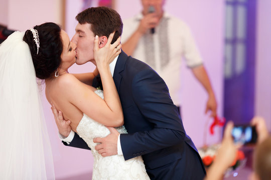 A passionate kiss of just married couple during their first danc