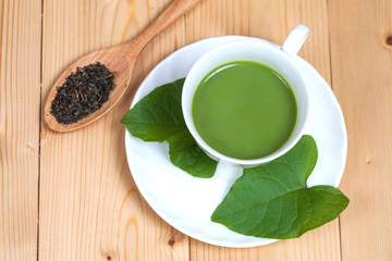 green tea with milk or hot matcha latte on wood