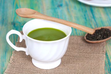 green tea with milk or hot matcha latte on wood