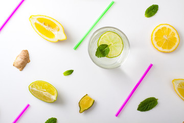 Flat lay ingredients for homemade lemonade. Lemon, lime, ginger and mint for refresh water lay in white background.
