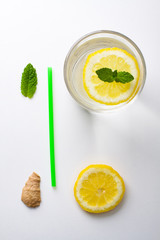 Flat lay ingredients for homemade lemonade. Lemon, lime, ginger and mint for refresh water lay in white background.