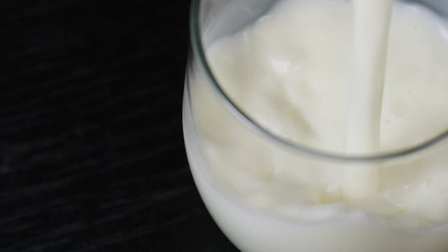 4K Chilled fresh milk being poured into a glass, in slow motion