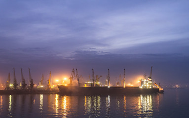 Fototapeta premium cargo ship in the port near the pier, night loading
