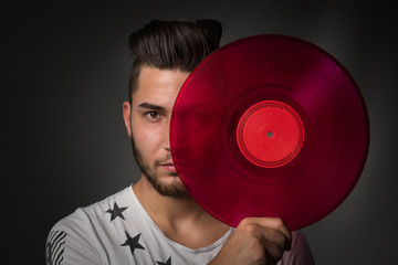 Junger Mann hält eine rote Schallplatte - freigestellt - cooler DJ 