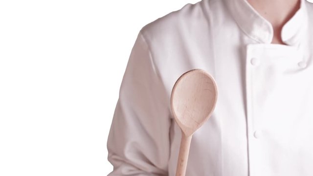 cuisini&egrave;re gros plan cachant l'objectif de la cam&eacute;ra avec une spatule en bois sur fond blanc