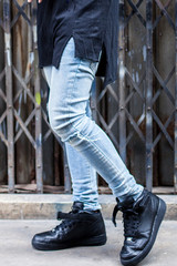 Young fashion man's legs in jeans on the street 