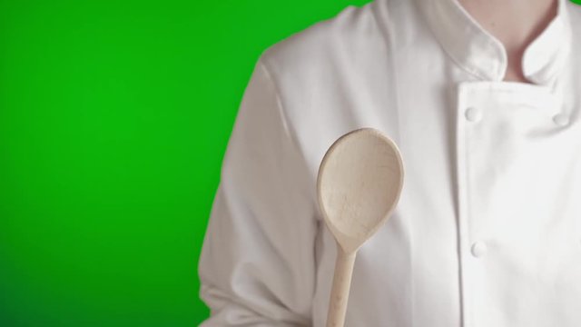 cuisini&egrave;re gros plan cachant l'objectif de la cam&eacute;ra avec une spatule en bois sur fond vert style de couleur flat