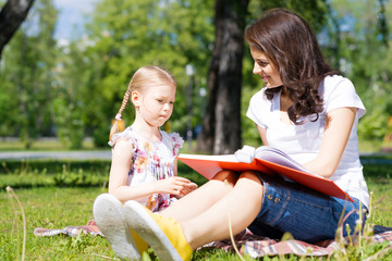 girl and a young woman reading a book together