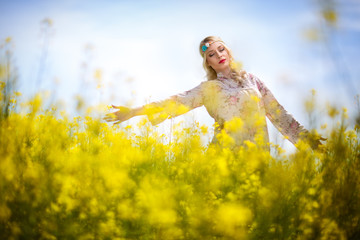 Beautiful woman in oilseed rape flowers