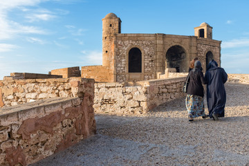 Fototapeta na wymiar People walking along old ramparts of Essaouira, Morocco