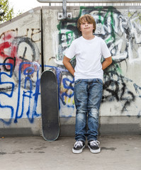 Naklejka na ściany i meble boy relaxes with his skate board at the skate park