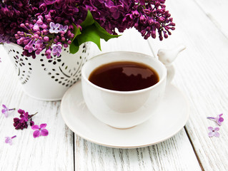 Cup of tea and lilac flowers