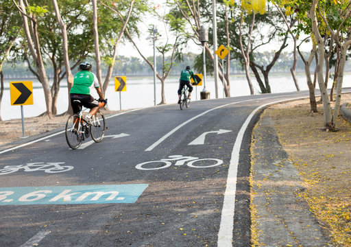 Focus on road sign bicycle lane couple peolple riding bicycle