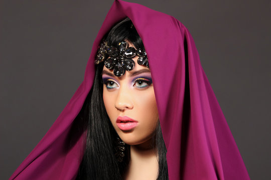 Portrait of a beautiful young woman in bordov?y fabrics, dark st