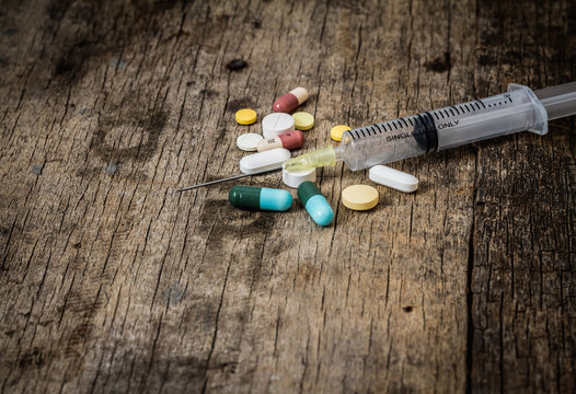 syringe and Drugs on the old wooden background