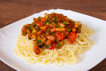 Spaghetti pasta with vegetables mix and bacon on white plate