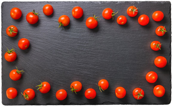 top view of beautiful red tomatoes on black slate background wit