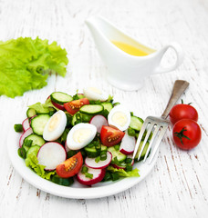 Spring salad with tomato, cucumbers and radish