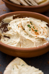 Hummus in brown bowl on slate