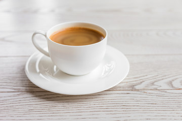 hot coffee in white cup on vintage wooden table