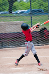 American teen baseball player swinging the bat. © tammykayphoto