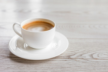hot coffee in white cup on vintage wooden table
